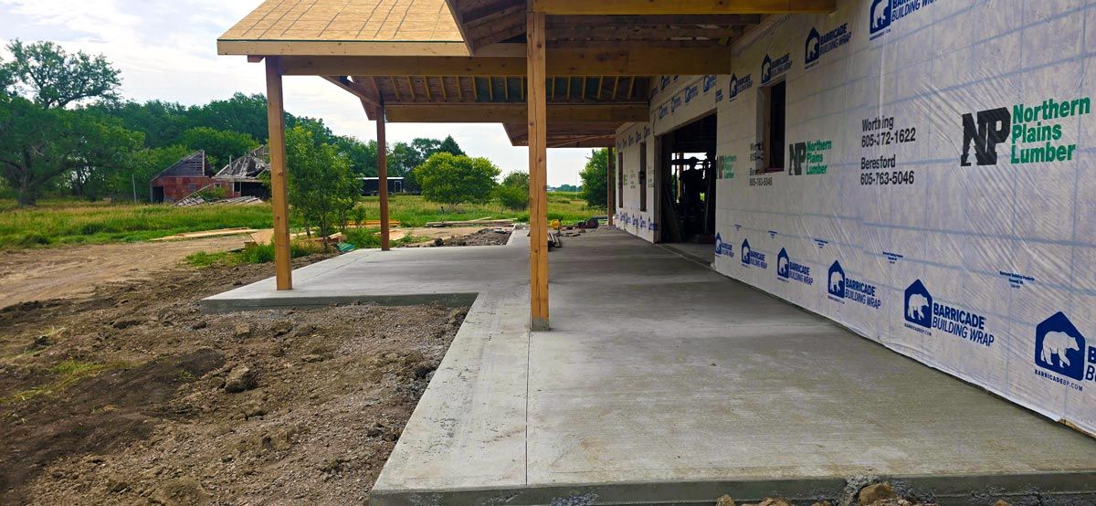 Covered porch and poured concrete flatwork on a custom home under construction, South Dakota