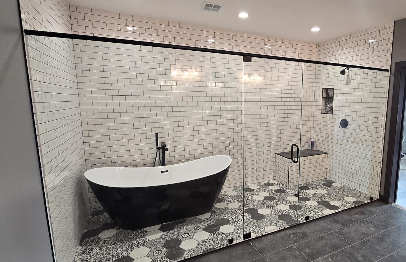 Primary bathroom with double vanity, dark cabinetry and walk-in closet beyond, Hahn Custom Homes